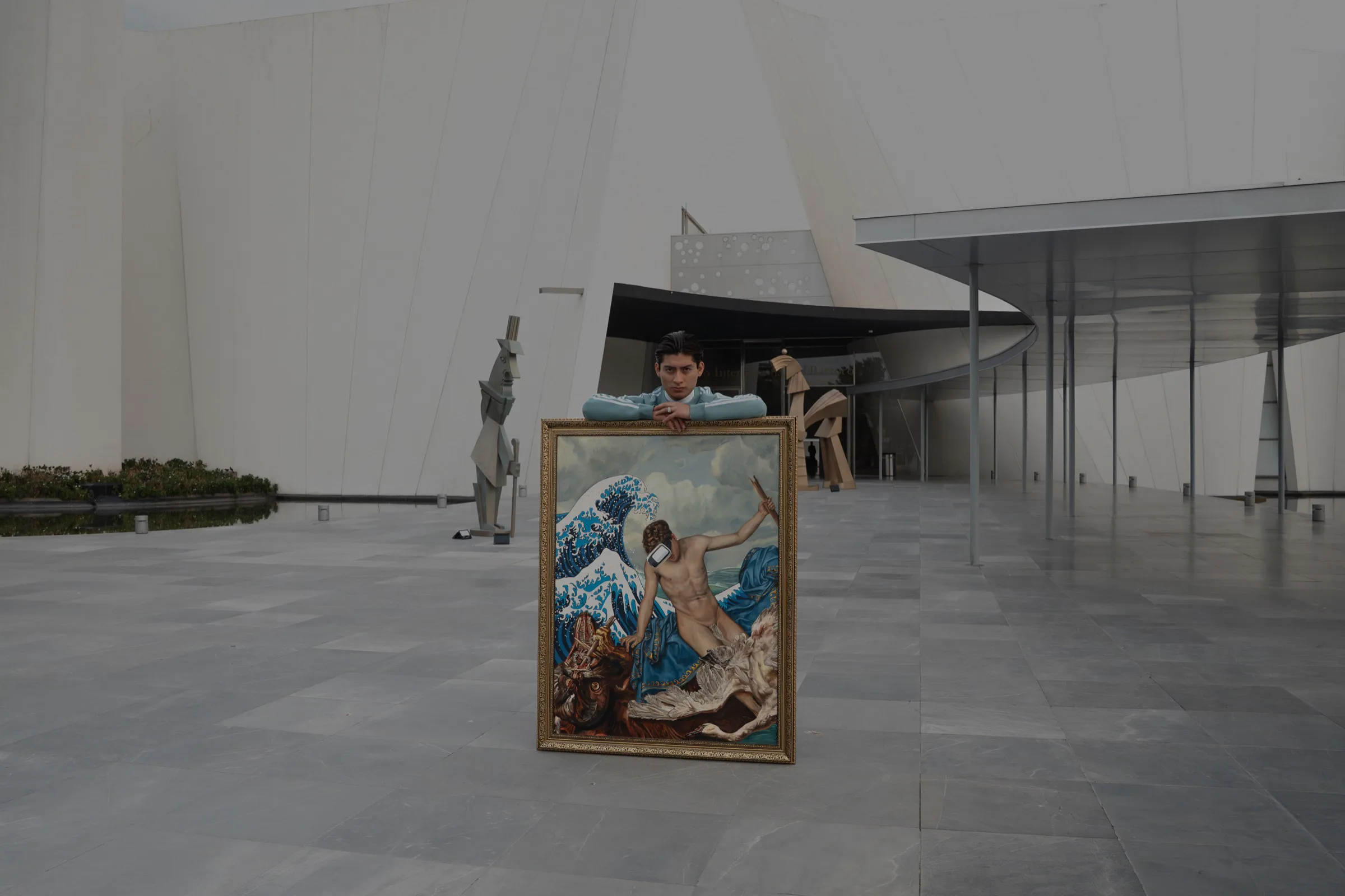 Jarett Aramis recargado sobre una de sus obras en el Museo Internacional del Barroco